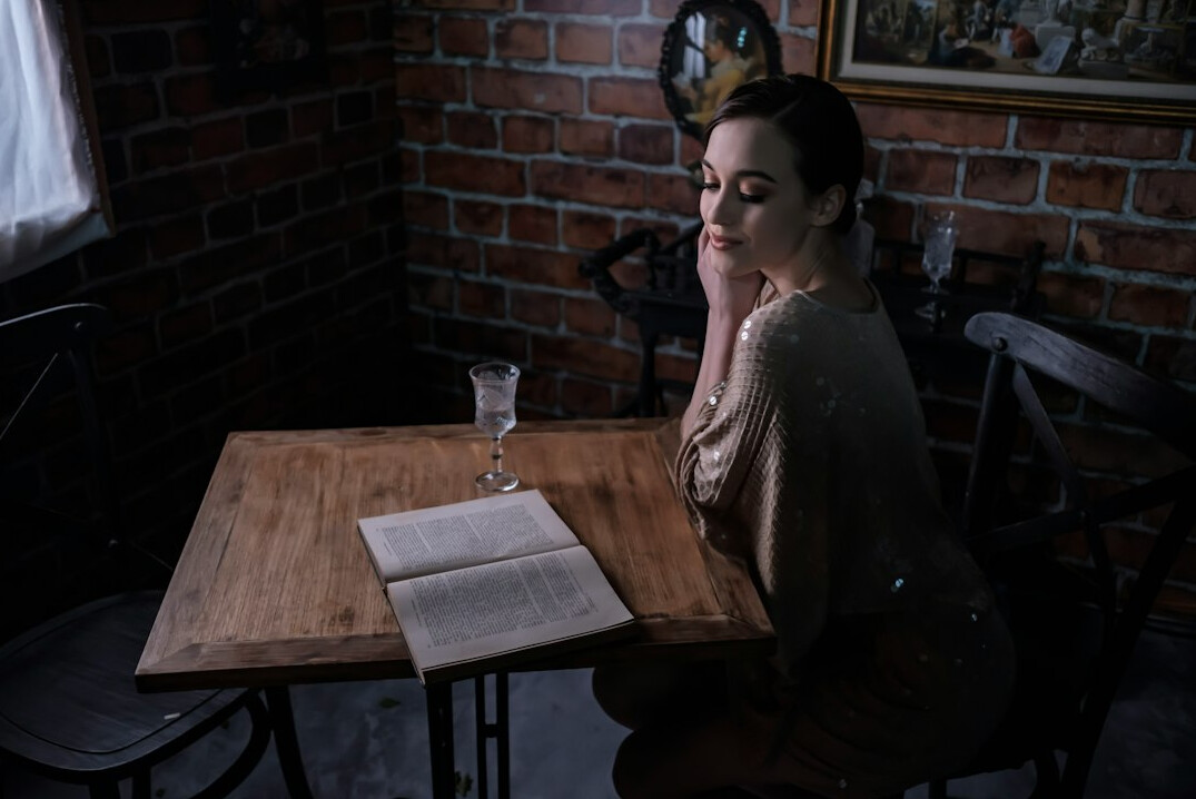 Woman in her fifties reviewing household expenses in a notebook at a kitchen table