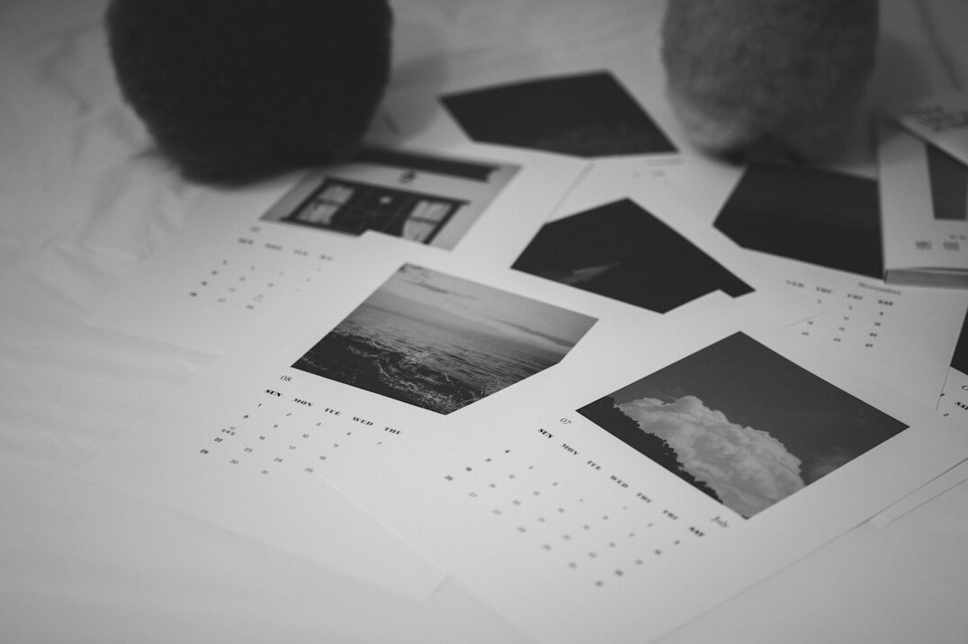 Monthly budget sheets with a calendar and laptop on a table