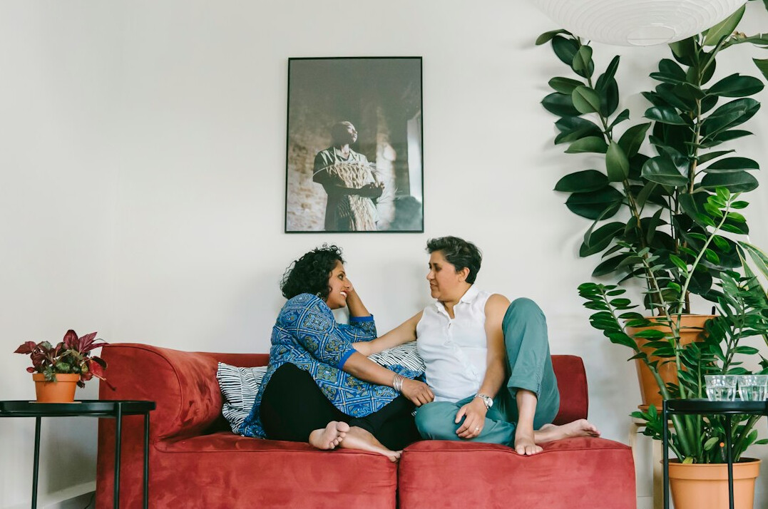 Mature couple discussing household expenses on a sofa with a notebook